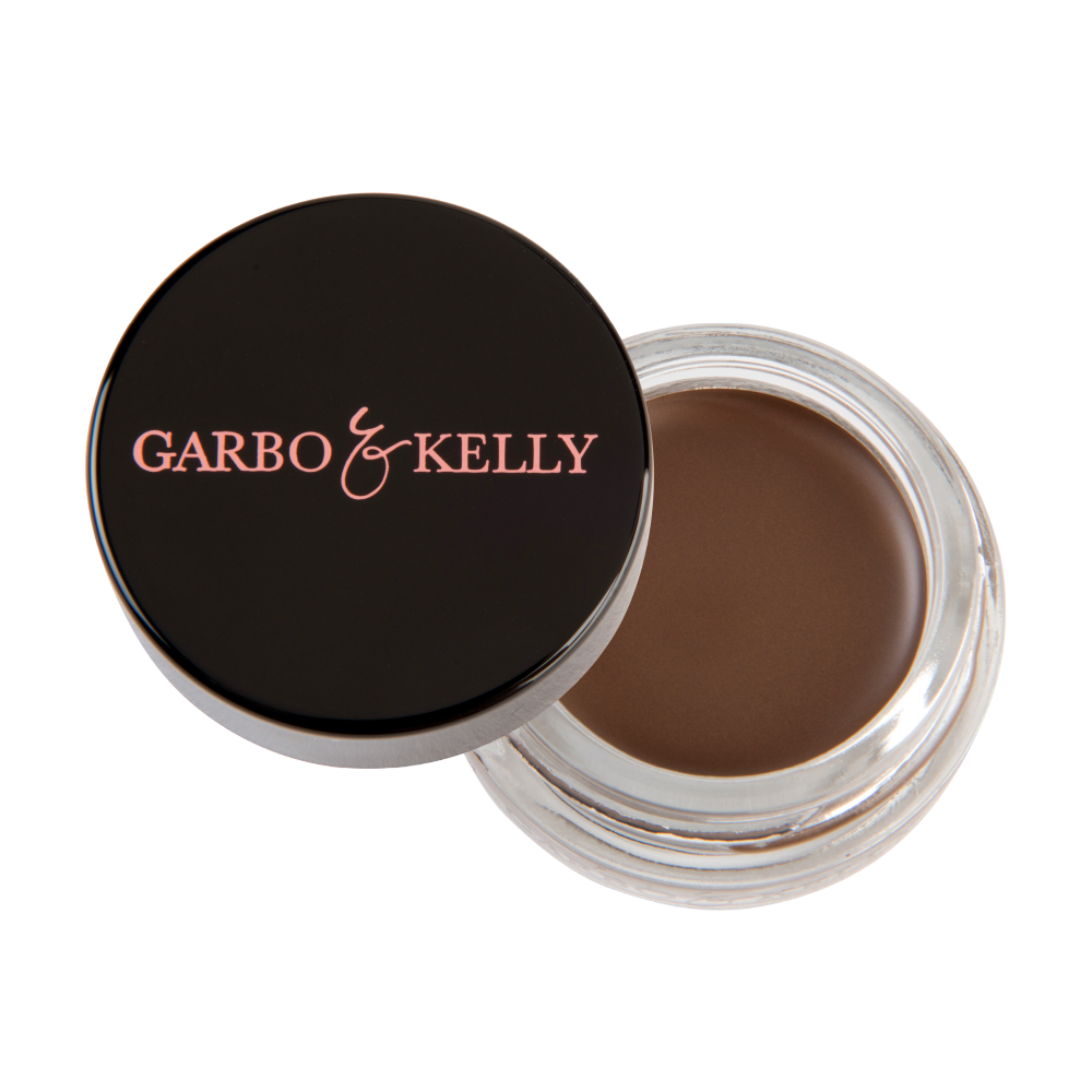 Close-up of Garbo and Kelly brow pomade in a sleek container, highlighting the creamy texture and rich color for defined brows.